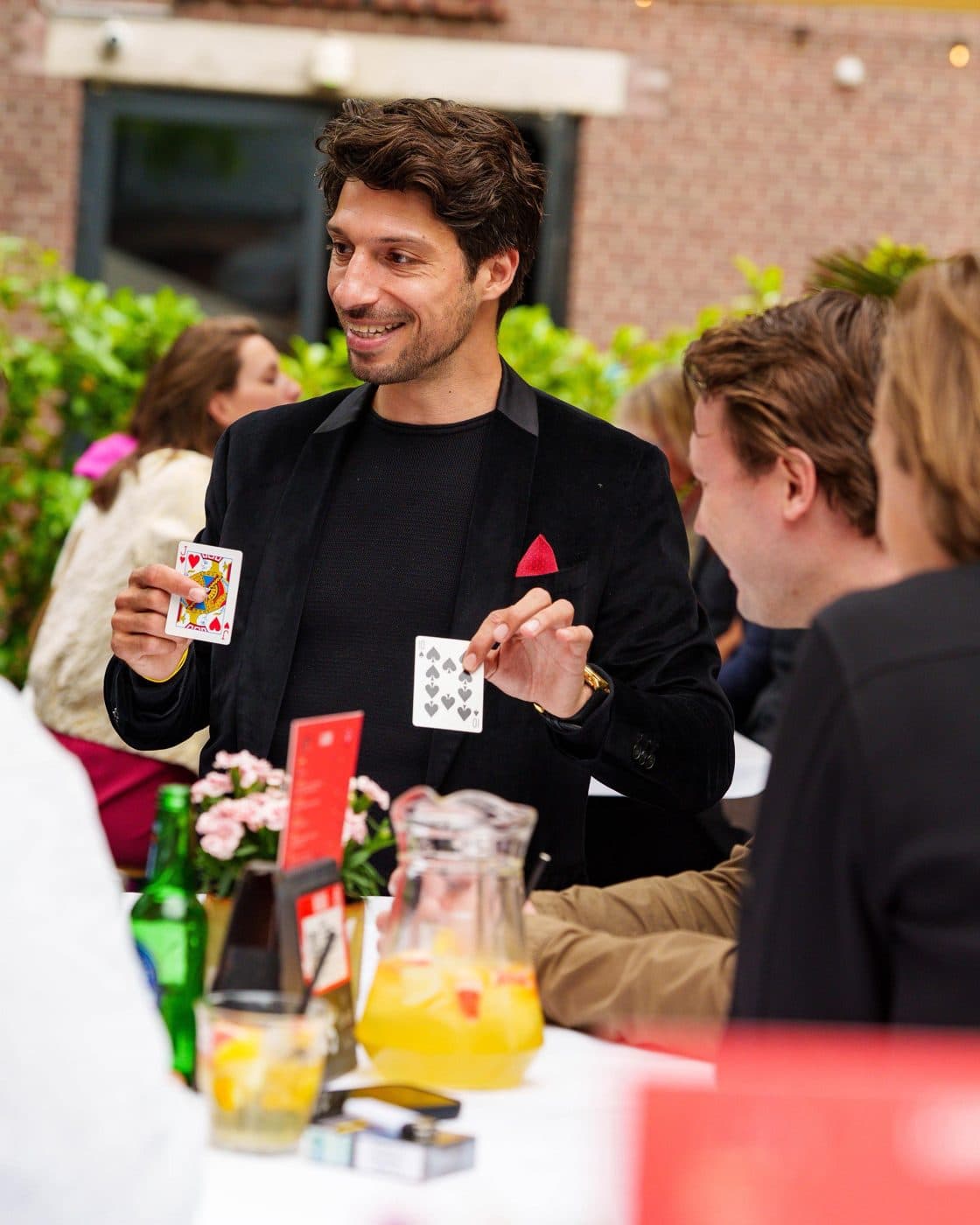 Lion showing a card to young guests at an outdoor table