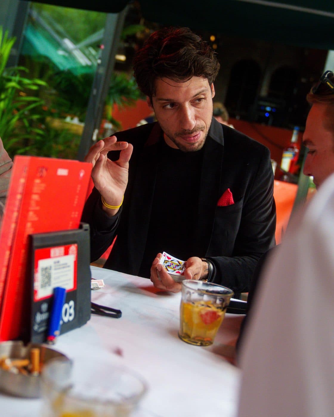 Lion aan tafel met deelnemers, een spel kaarten en drankjes