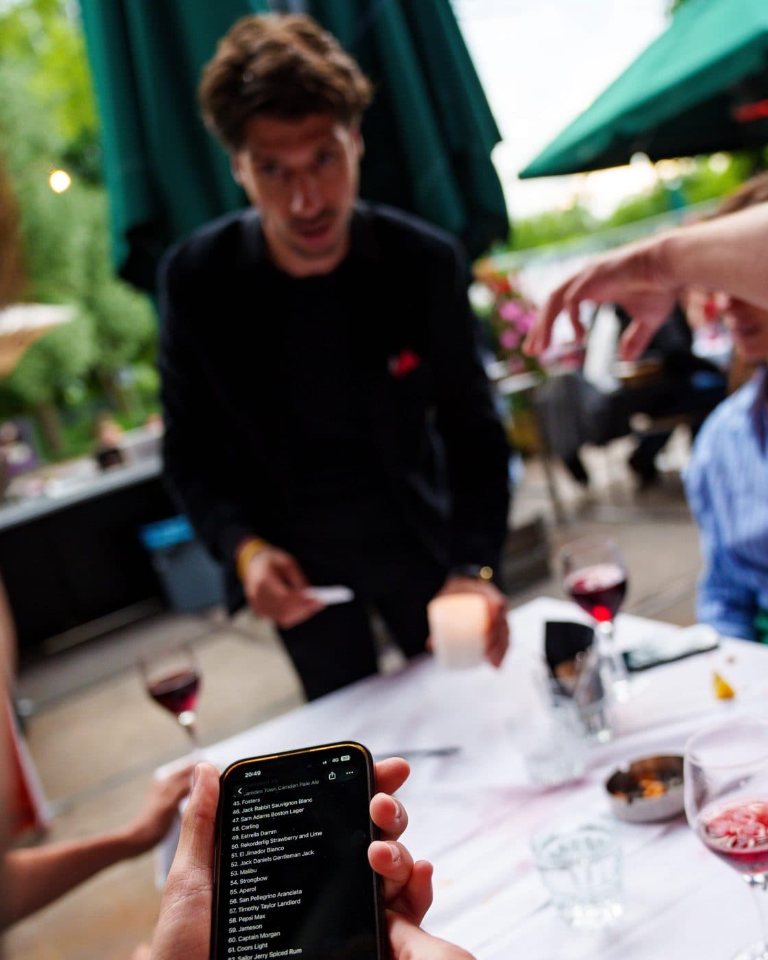 Lion at a terrace table while a guest holds up a phone for a trick